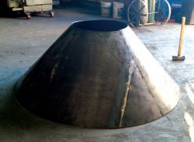 A large metal cone sitting on top of a floor.